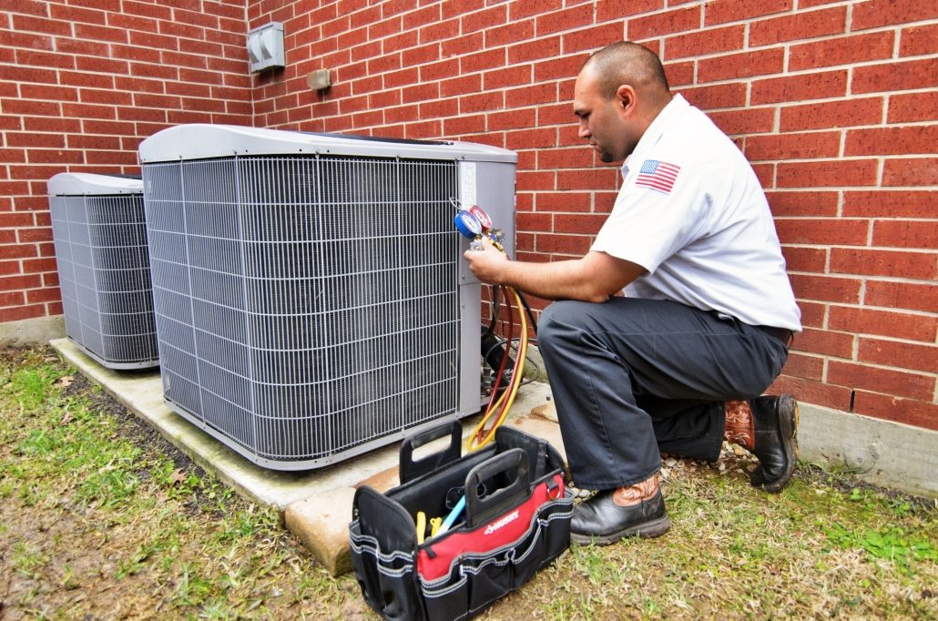 HVAC technician performing a maintenance service on an AC unit