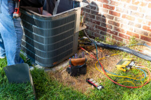 A service technician working on a condenser unit