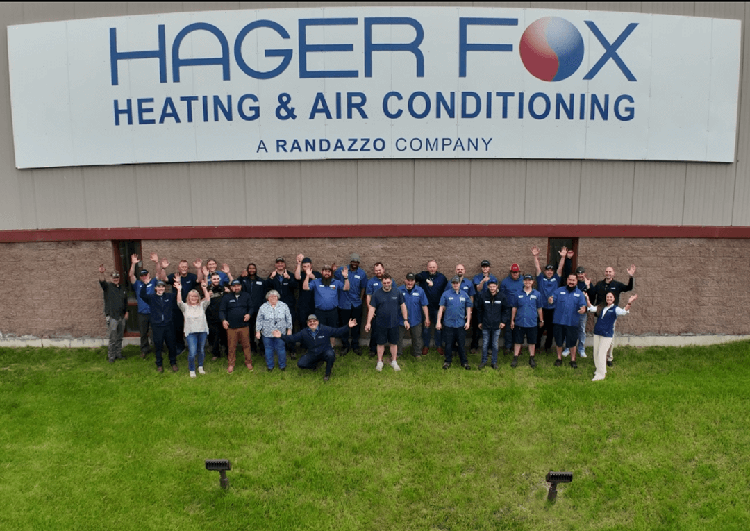 Team standing in front of building cheering