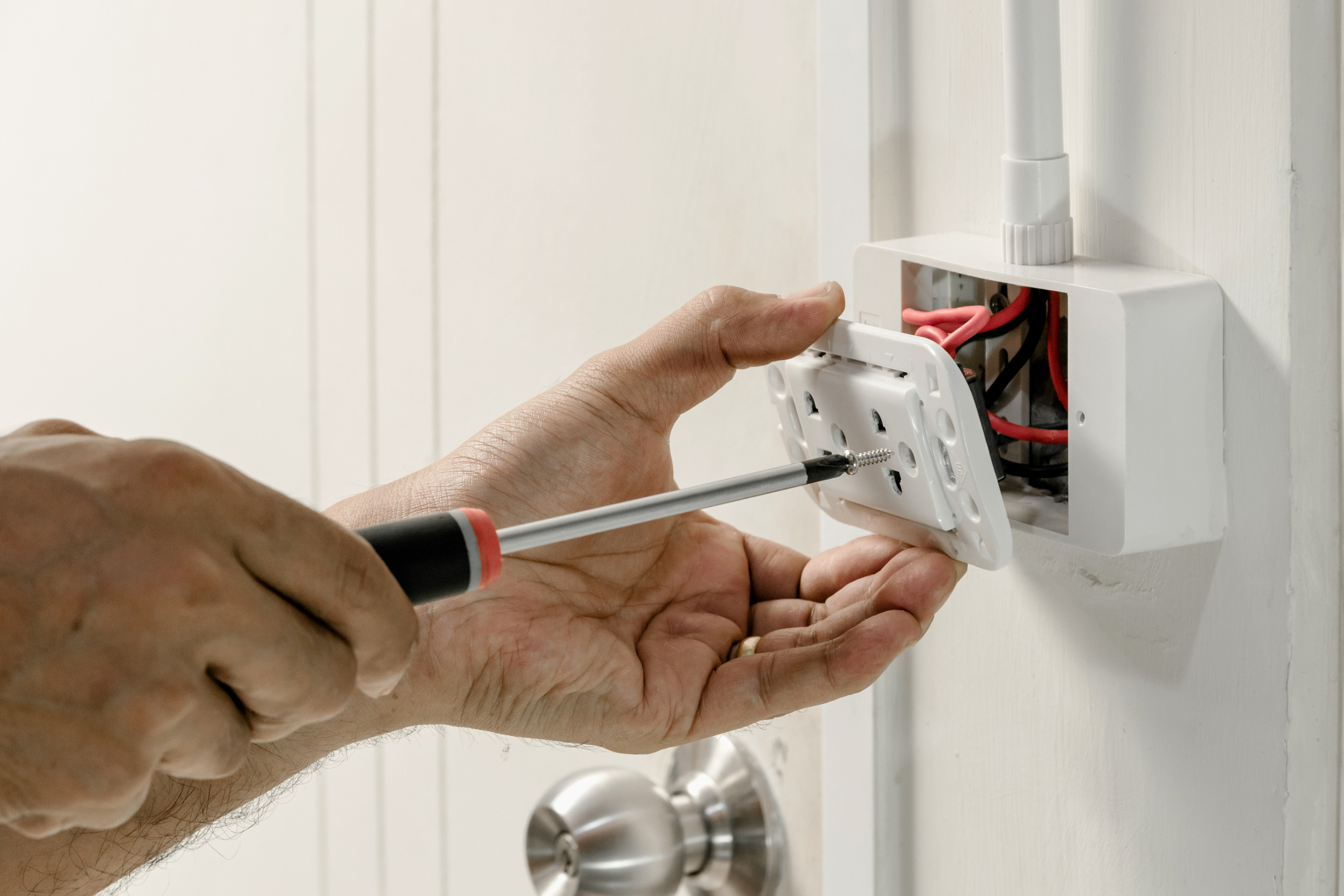 Electrician installing a new outlet in a Battle Creek home