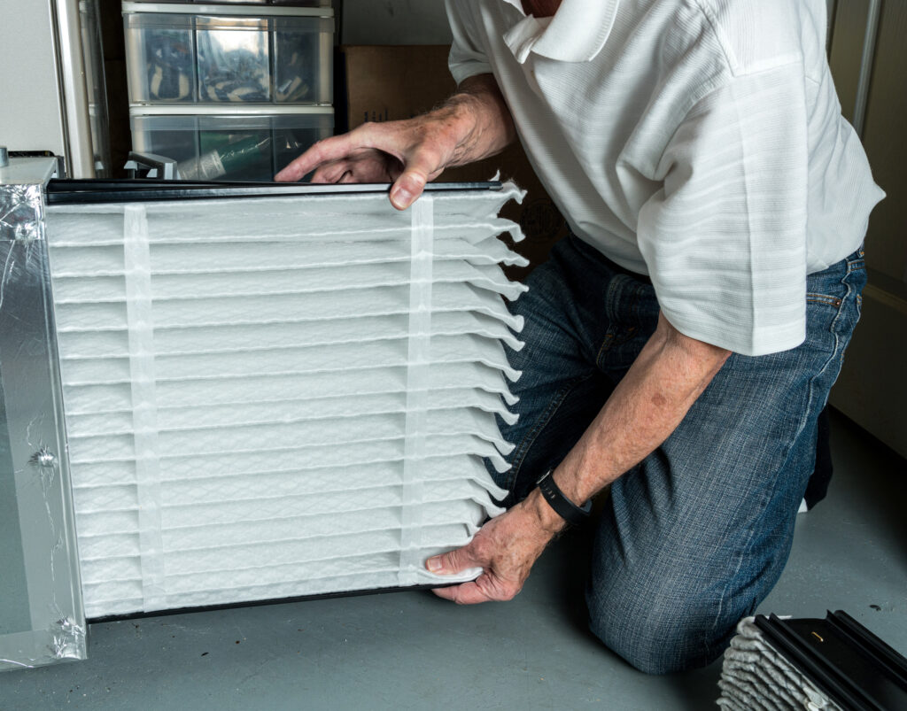 HVAC technician replacing a furnace filter