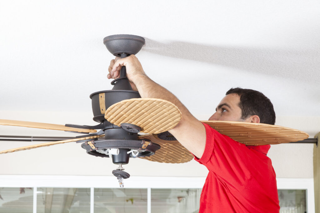 Electrician installs a new ceiling fan for residential customer