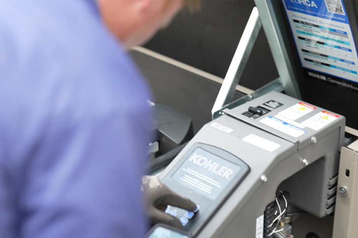 Technician operating a Kohler generator control